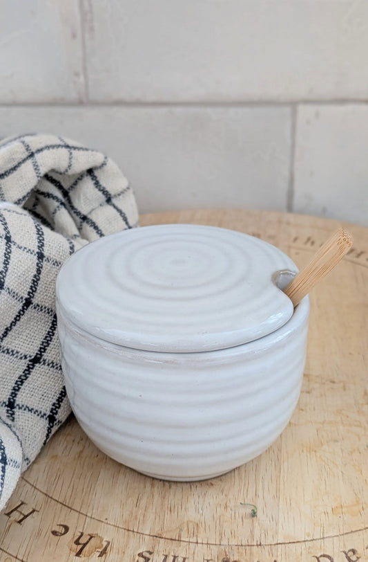 white ceramic cup with lid and spoon, sugar bowl